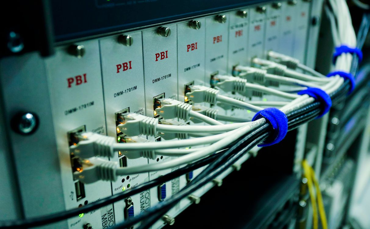 Detalhe de cabos de rede conectados e organizados em equipamentos de infraestrutura